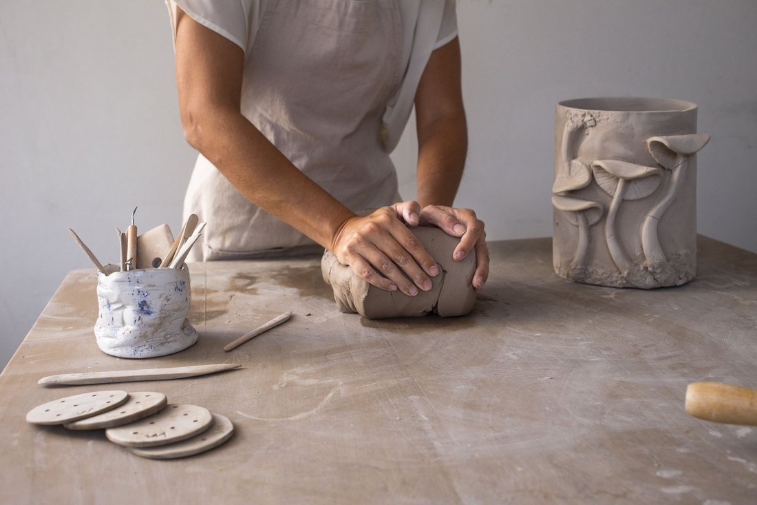 Hands shaping clay in the Nuna Terra Ceramics studio